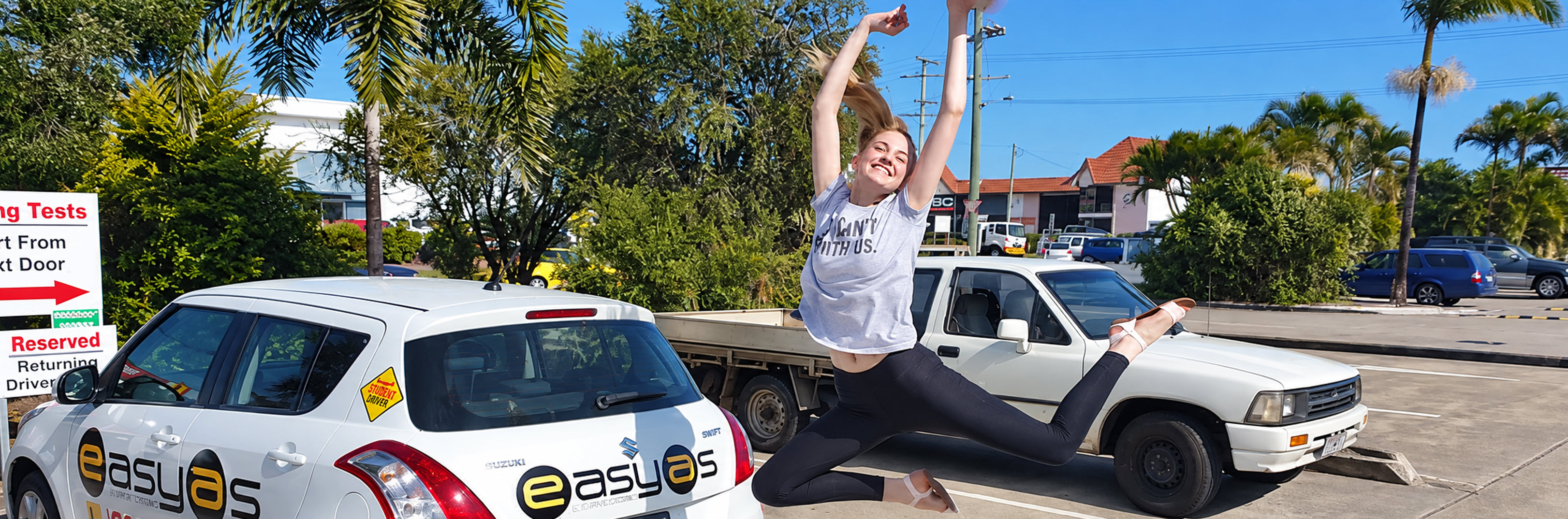 Student jumping for joy next to an easyas car