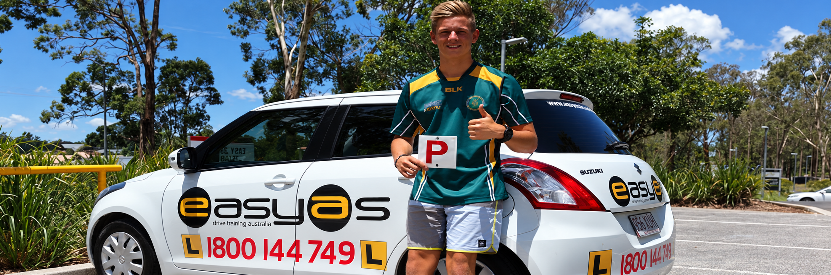 Young man holding a red P plate beside a white EASYAS Suzuki