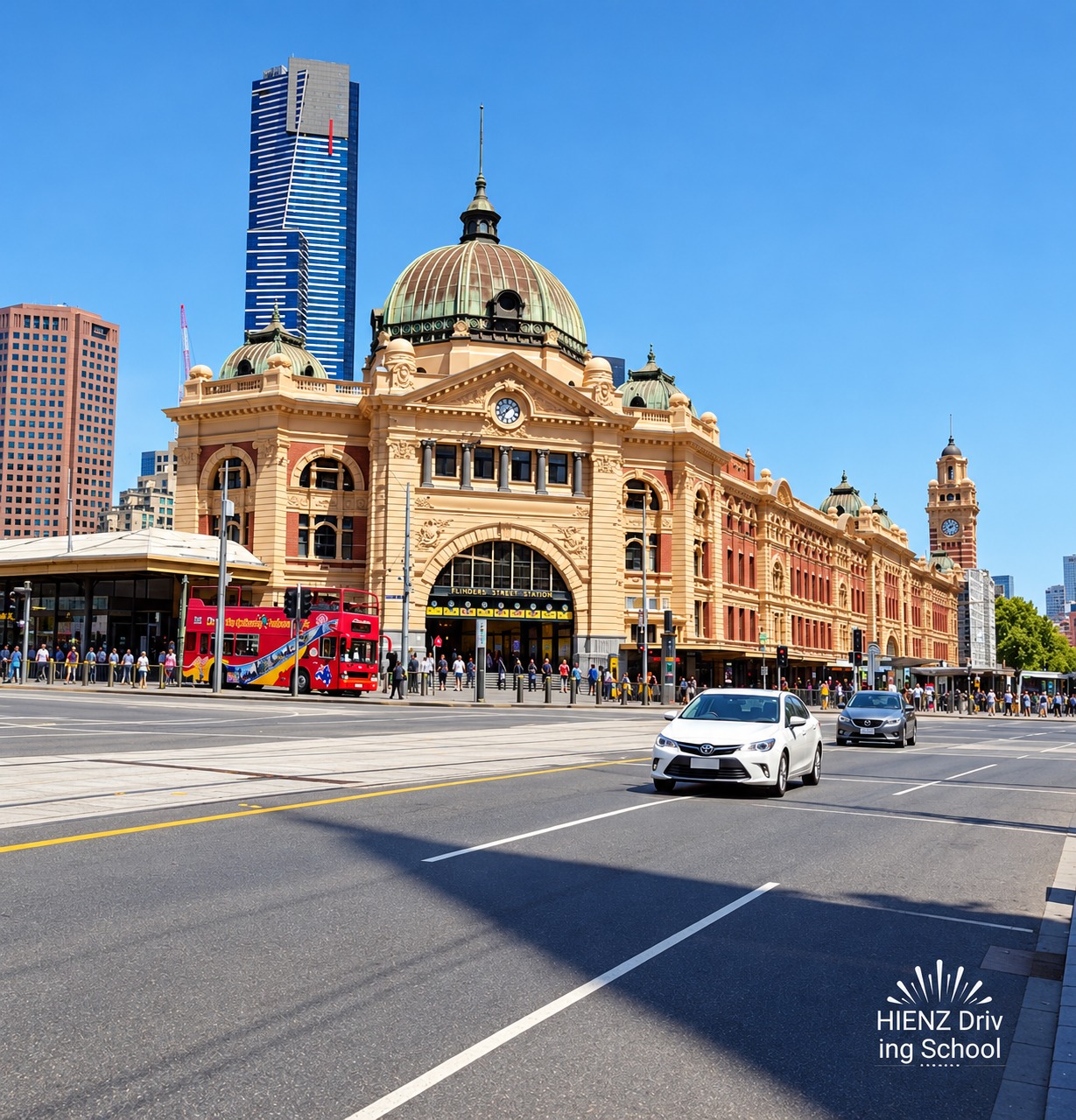 Flinders Street Station and Melbourne city skyline beside a city intersection