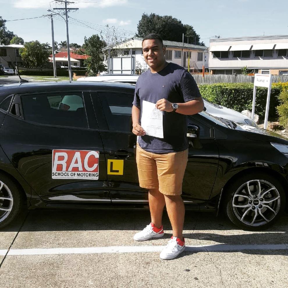 RAC student celebrating beside a branded learner car