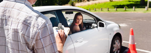 Instructor evaluating a young woman's practical driving test for a driver's license.