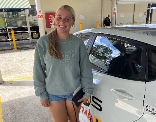 Young woman smiling beside a white EASYAS car