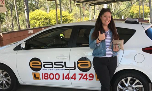 Woman giving a thumbs-up beside a white EASYAS car