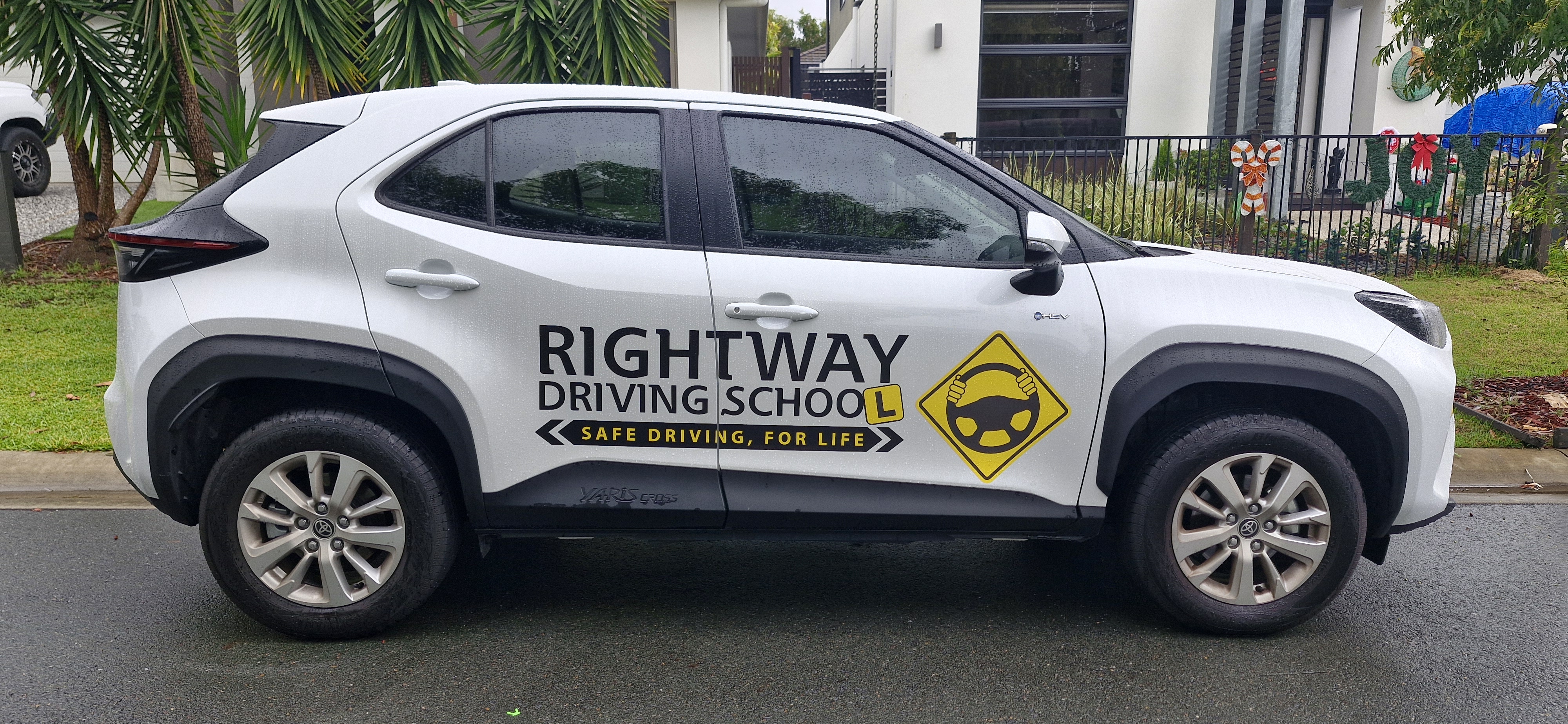 White Rightway-branded SUV photographed side-on beside a residential building.