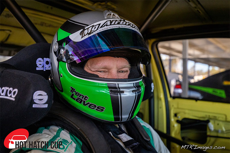 Professional Instructor, Trent Laves, sitting in a race car with helmet and armour.