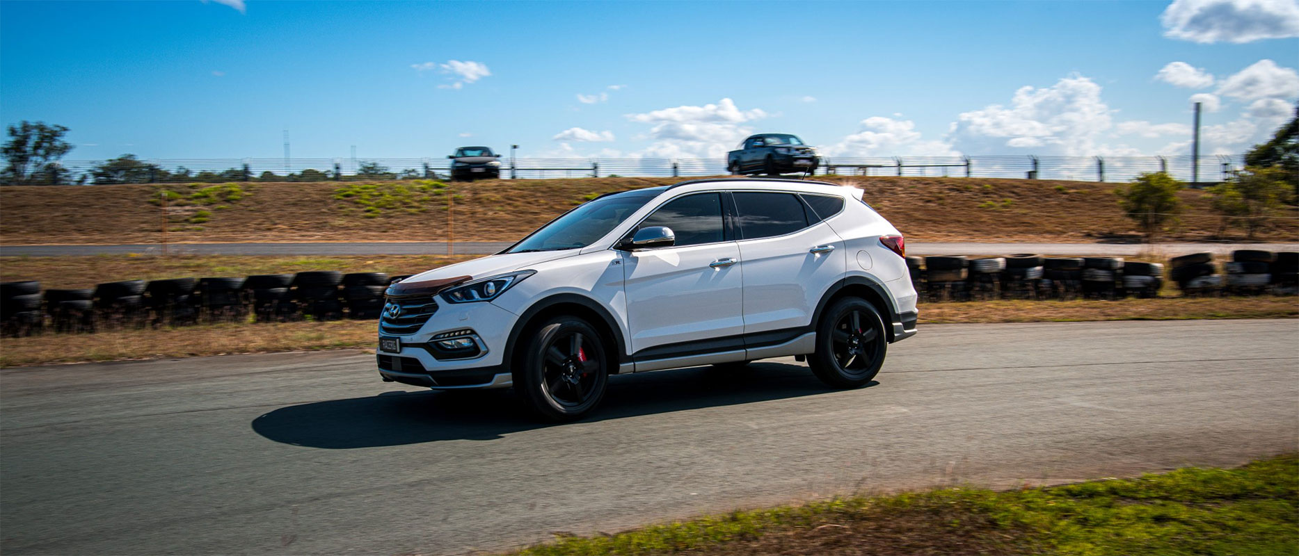 A white family car parked on track.