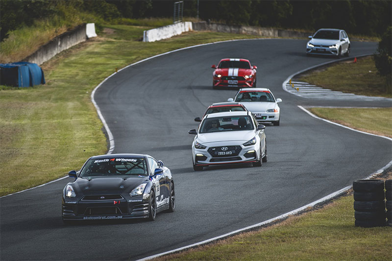 A line of cars on a slalom section of a race track.