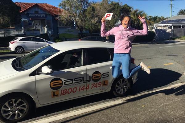 Woman jumping beside an EASYAS car with a red P plate