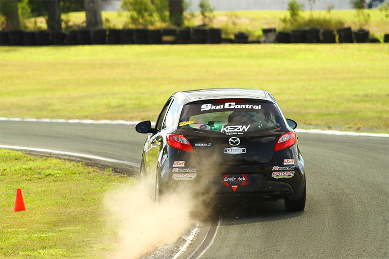 Black Hot Hatch Cup driving on the run-off area of a track.