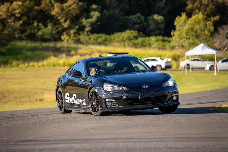 Black Subaru BRZ driving on a track.