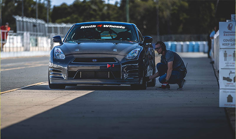 Professional Instructor, Hudson Sinclair, inspecting a car on the track pits.