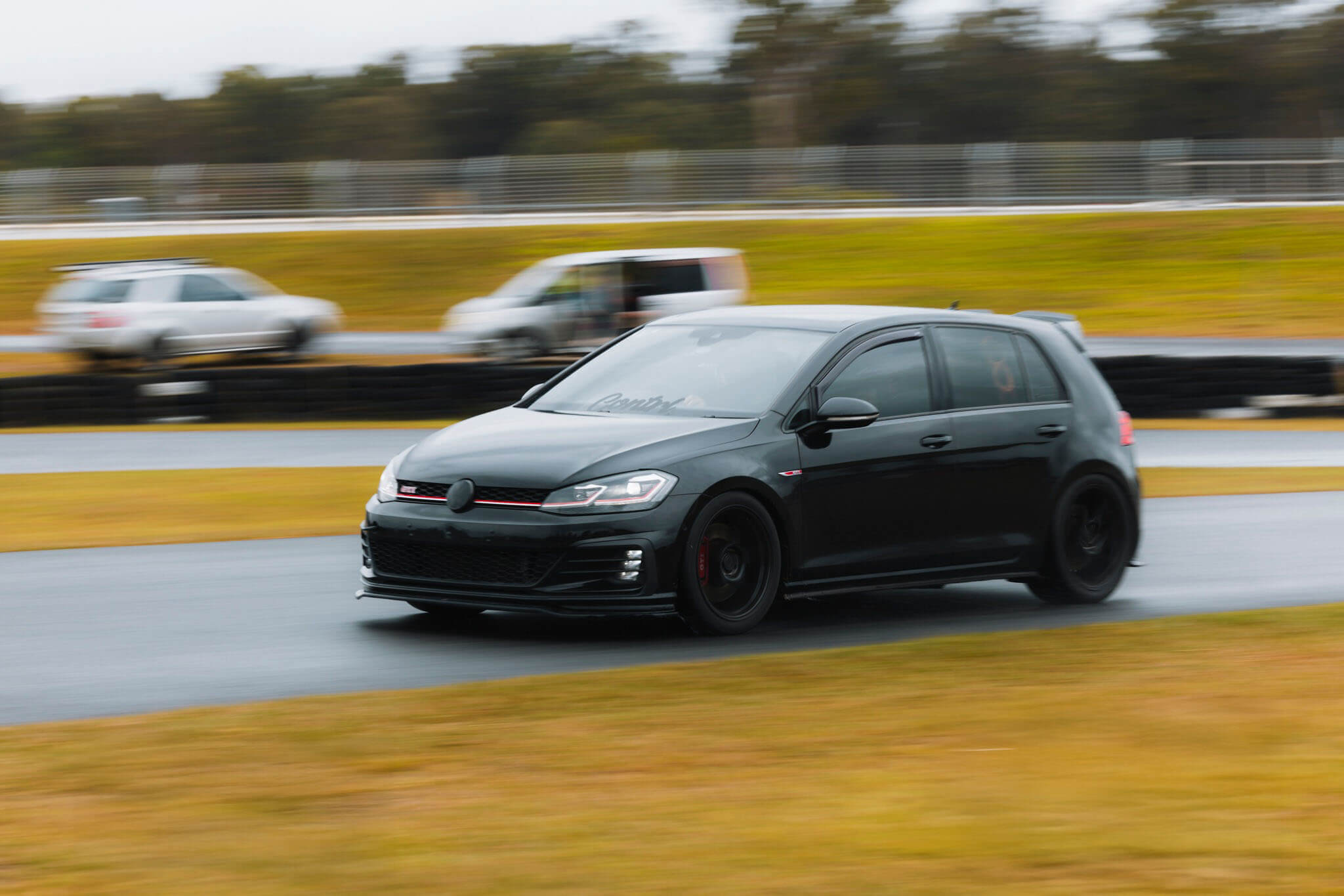 Black car at tarmac rally sprint track.