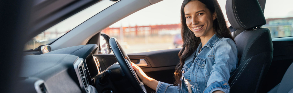 Smiling woman in the driving seat of a car on a driving lesson.