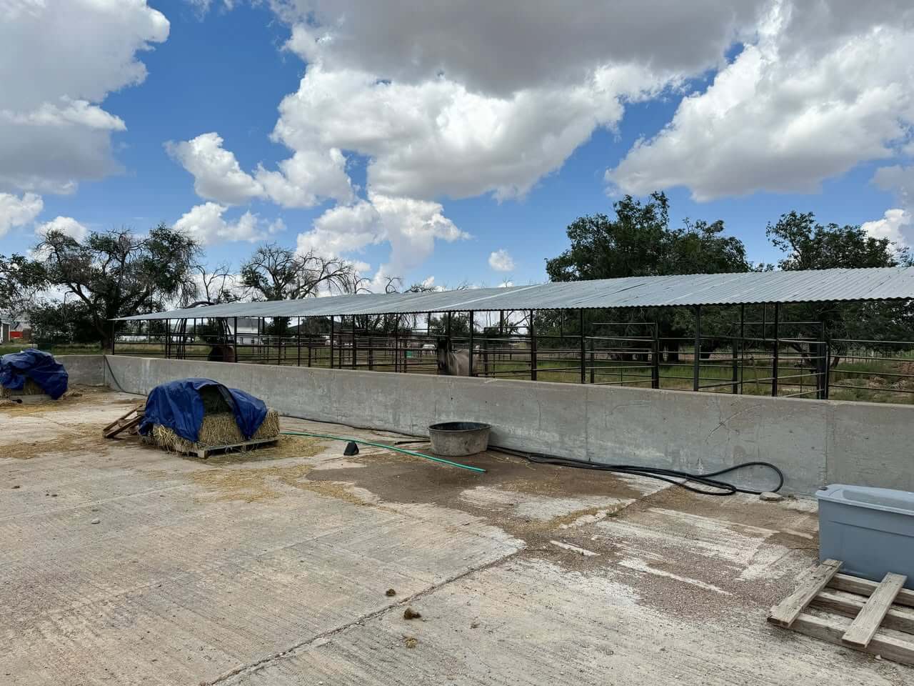 Long covered shelter and concrete wall.