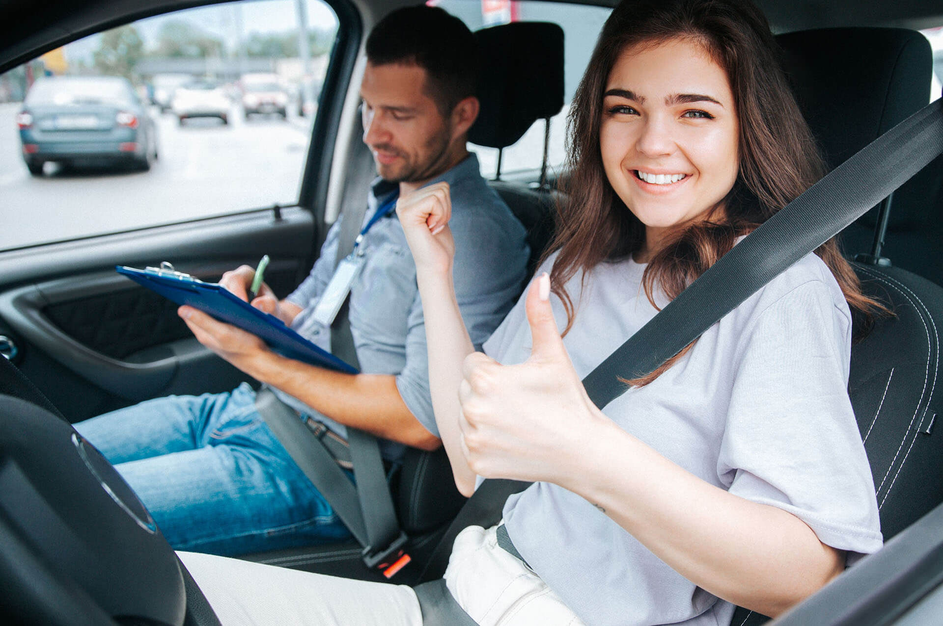 Teen driver smiling from a car window