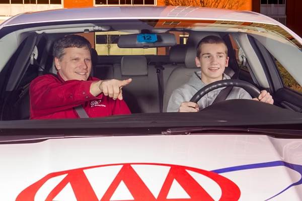 AAA driving instructor seated beside a student during a behind-the-wheel training session.