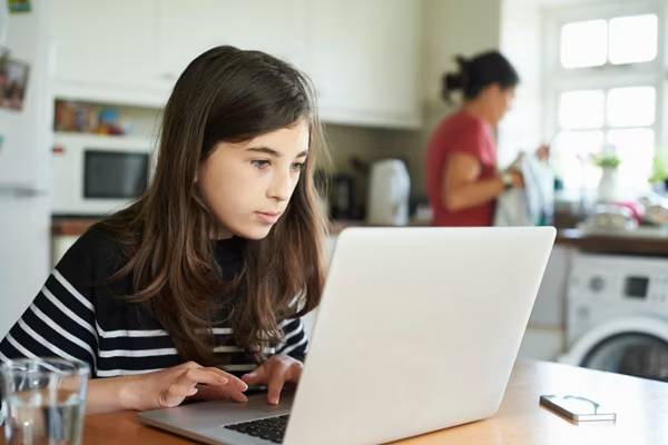 Teen student managing driving lesson appointments on a laptop.