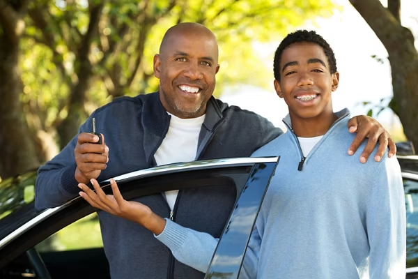 Adult driver smiling beside a car, ready for a private driving lesson.