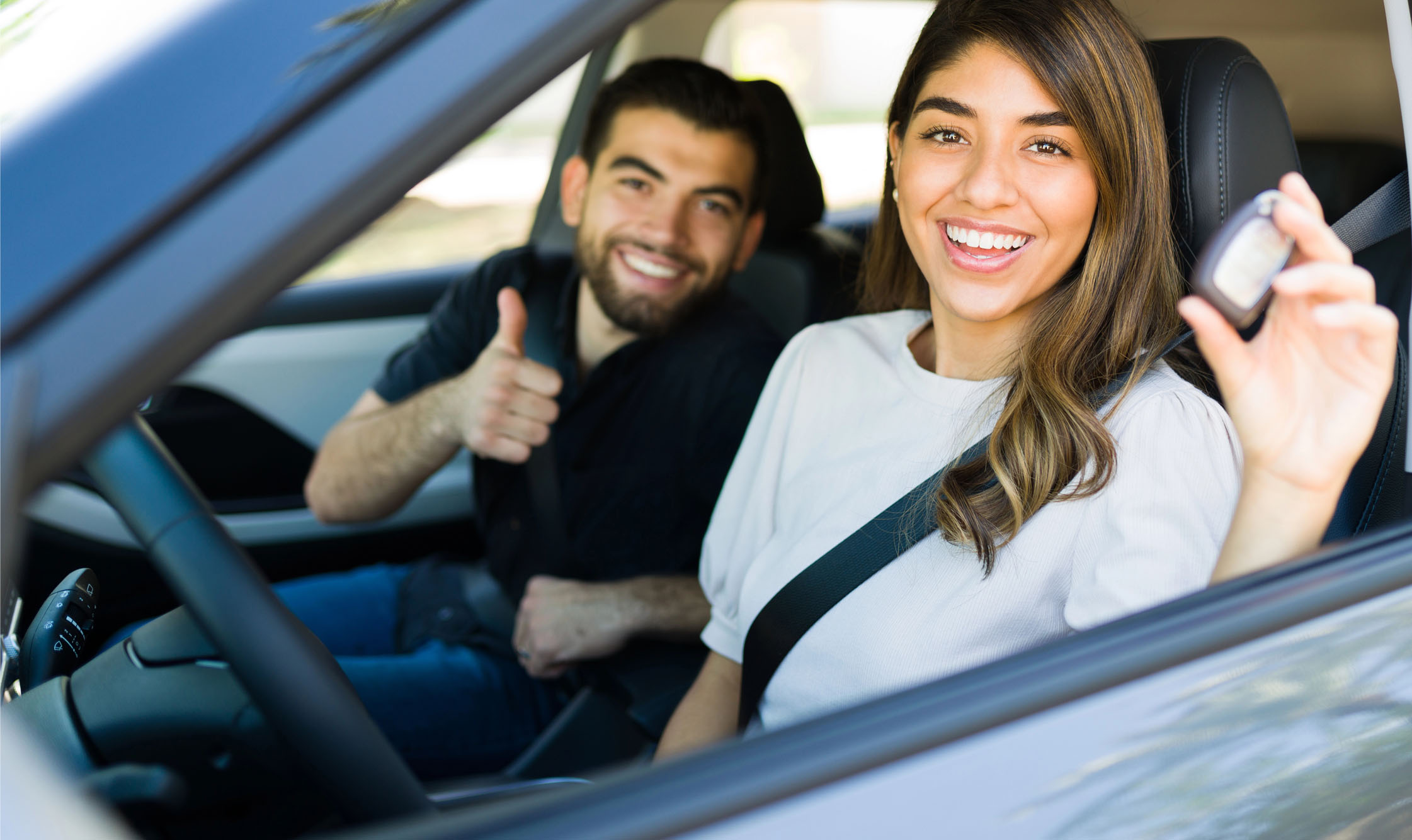 Teen driver smiling from a car window