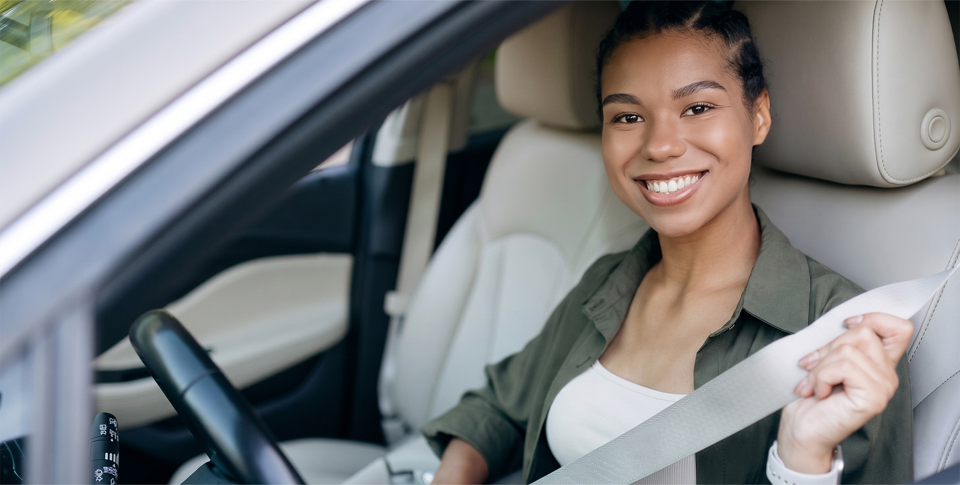 Teen driver smiling from a car window