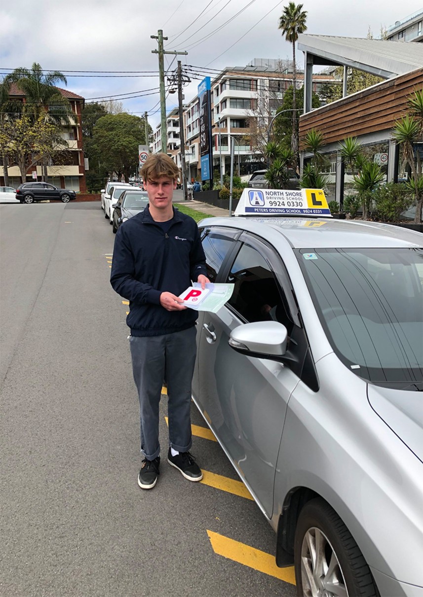 North Shore Driving School student proudly holding P plates after passing their NSW Practical Driving Test