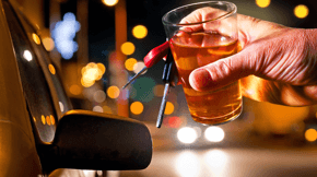 Person reaching for a drink while driving