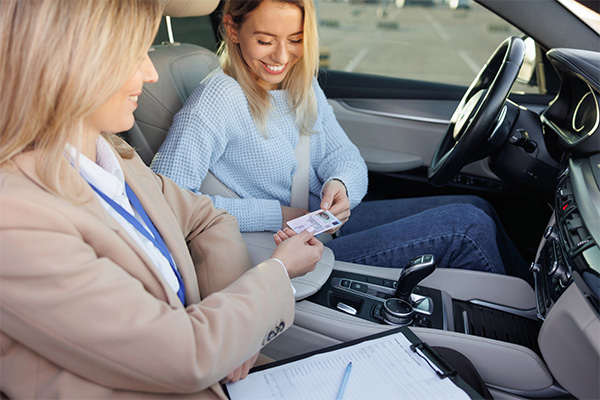 AAA instructor and teen driver reviewing a permit before a behind-the-wheel lesson.