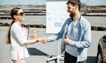 Driving instructor greeting a student before a lesson