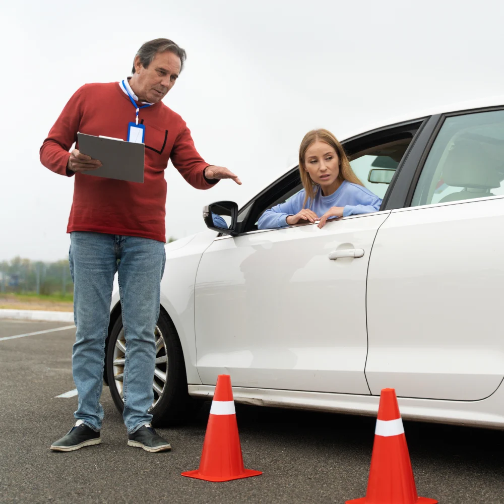 Instructor evaluating a driver next to test cones