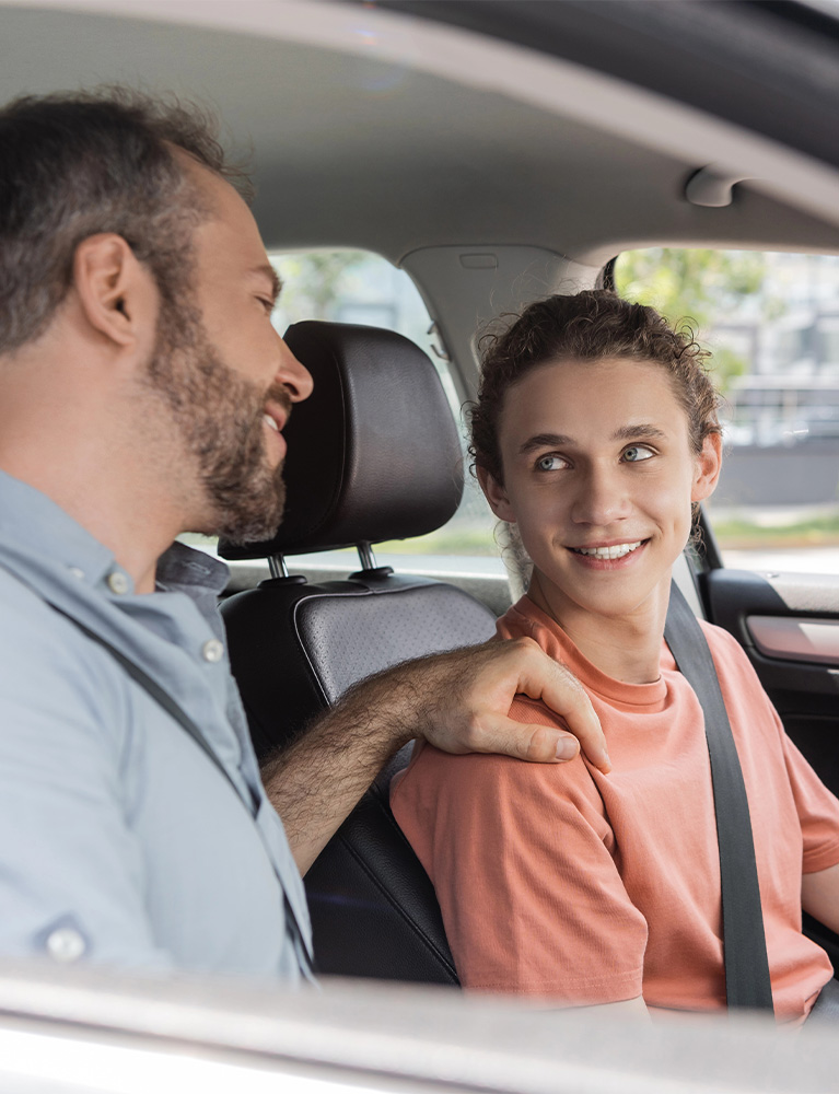 Parent helping a teen learn safe driving skills